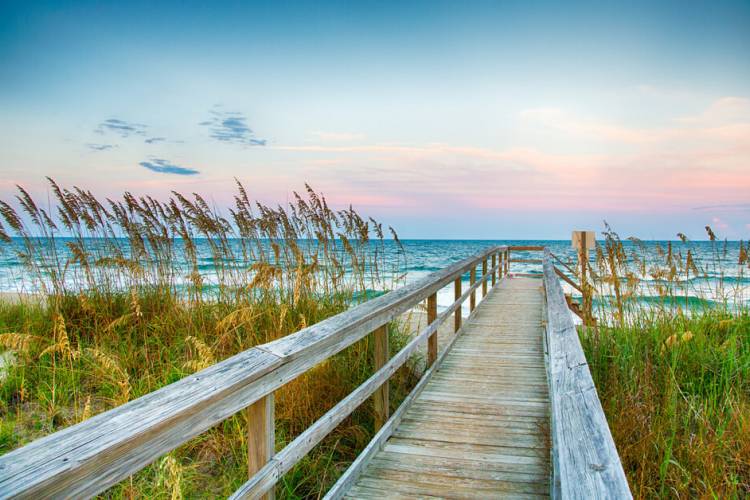 boardwalk toward the beach at sunset. 