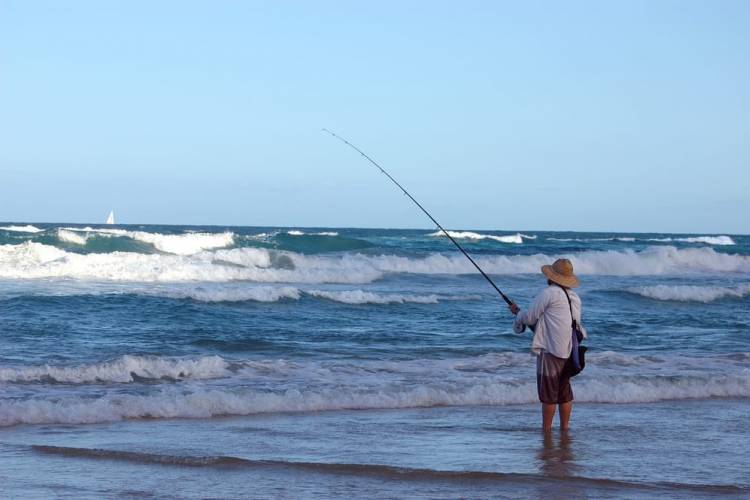 man fishing in the surf of Cape Point, NC