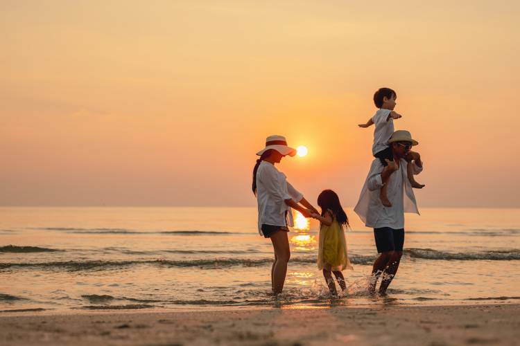 family on beach at sunset