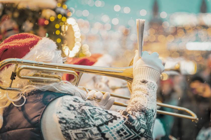 santa in a christmas parade playing a trombone