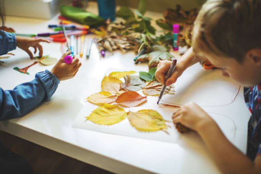 kid doing art with leaves