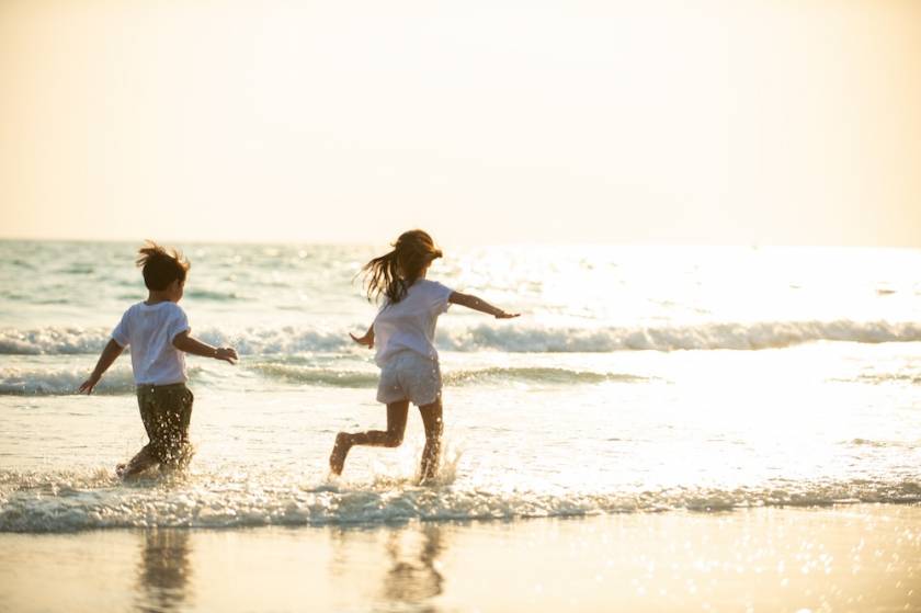 two kids running on beach