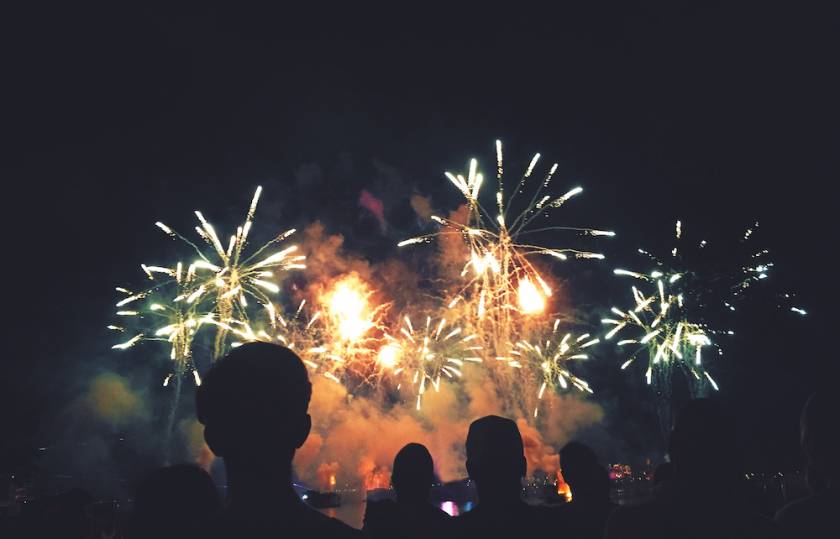 people watching fireworks over water